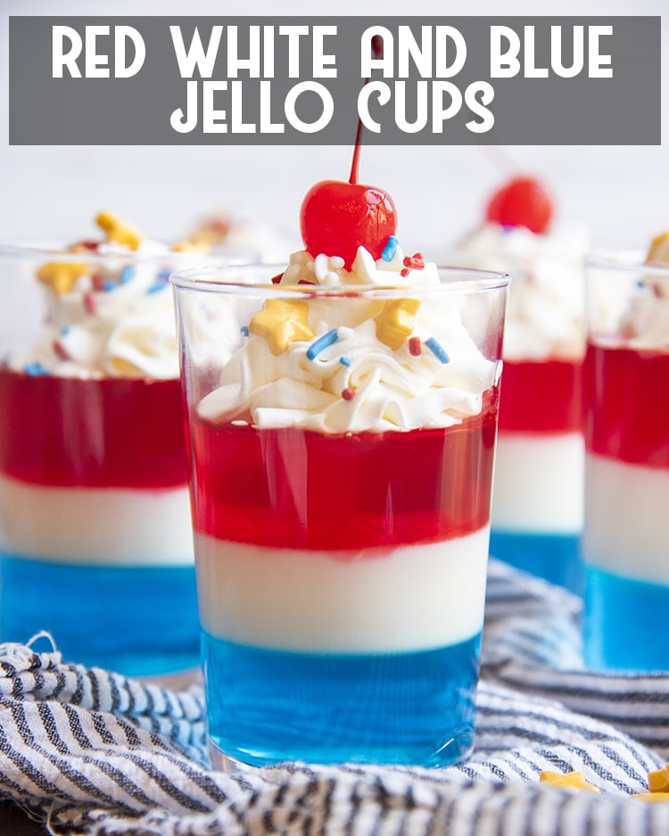 Layers of Red White and Blue Jello in a cup with whipped cream and a cherry on top with text overlay for pinterest