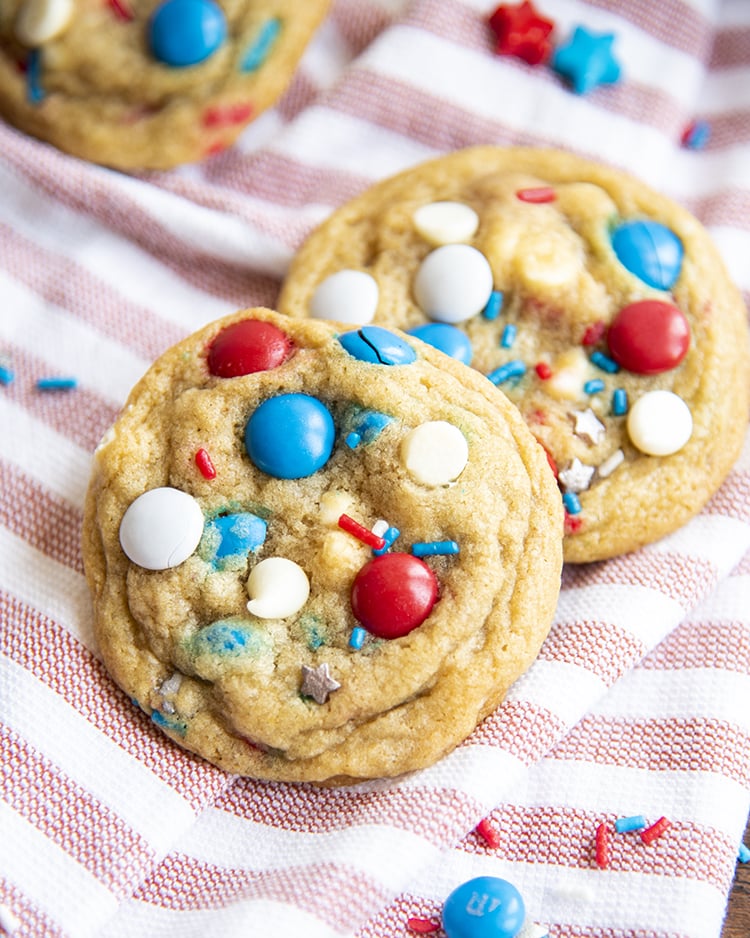 Fourth of July Cookies filled with red white and blue m&ms on a red and white cloth.