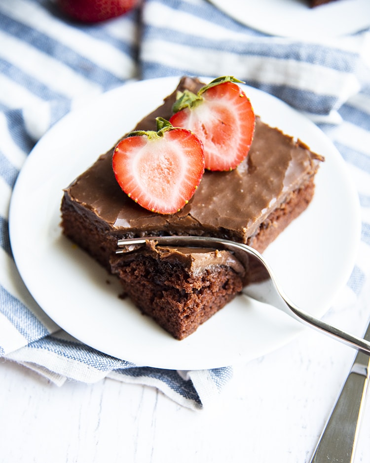 A slice of Texas sheet cake with a fork cutting a bite out