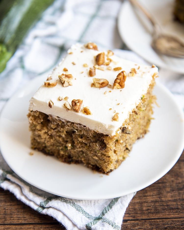 Zucchini cake with cream cheese frosting and pecans.