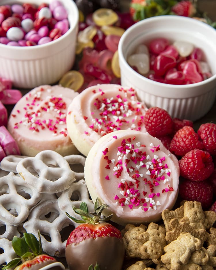 A Valentine\'s day dessert board of a variety of pink and valentine\'s day desserts.