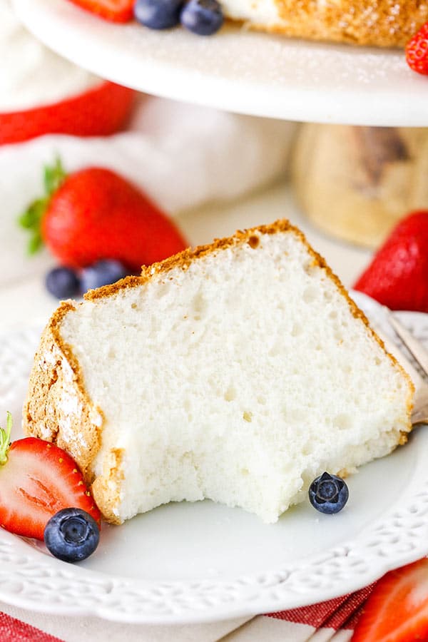 A slice of angel food cake on a plate with a bite taken out of it.