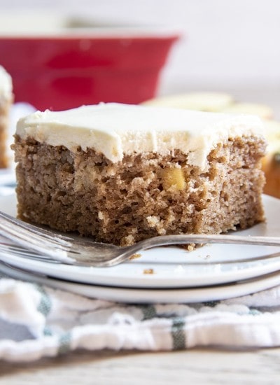 A piece of apple cake with a bite out of it on a plate.