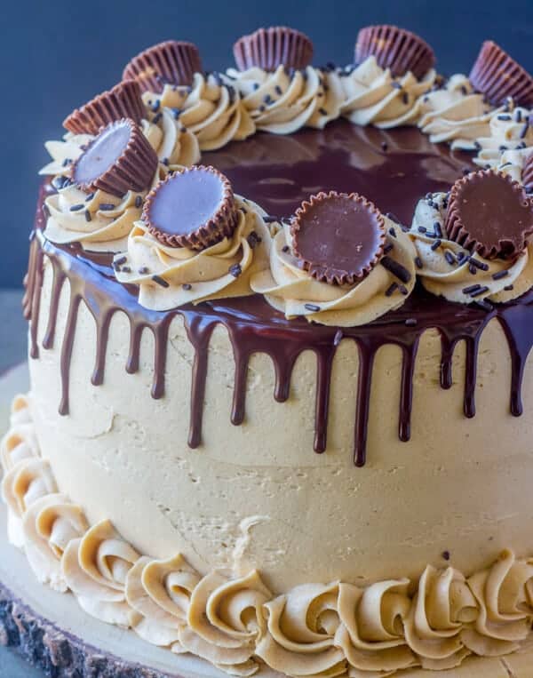 A layered peanut butter cake topped with chocolate ganache and peanut butter cups.