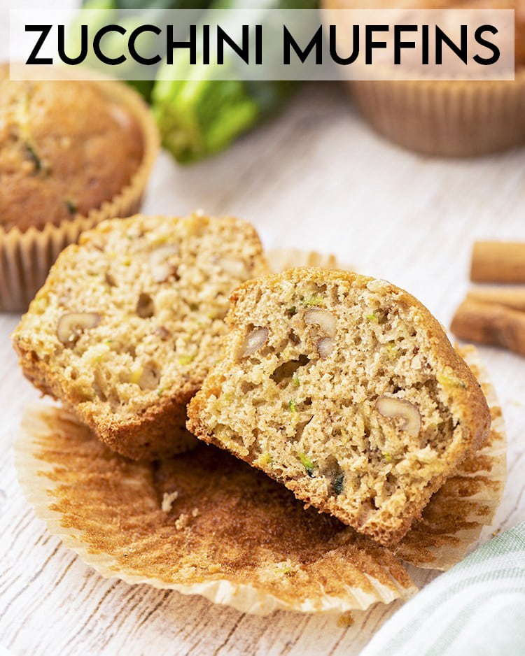A zucchini muffin cut in half down the middle on a muffin liner with text overlay saying zucchini muffins.