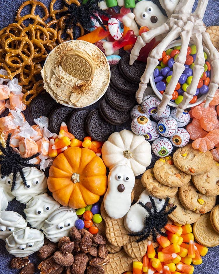 A close up or cookies, and Halloween treats piled together.