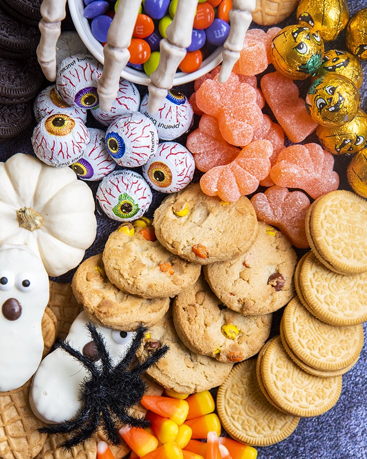 A close up or cookies, and Halloween treats piled together.
