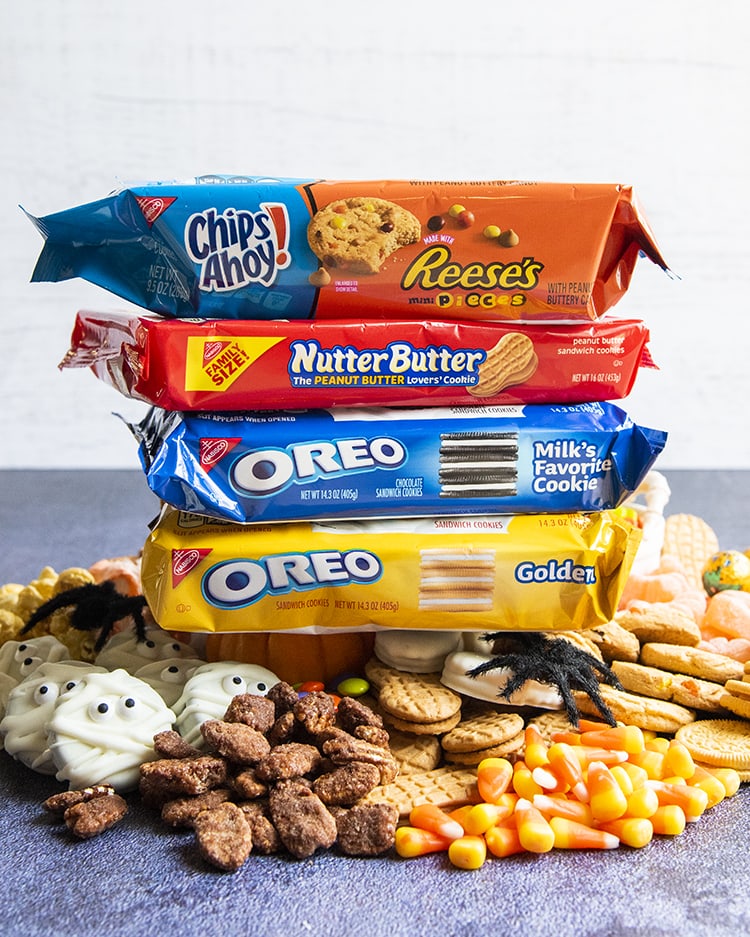 A stack of Chips Ahoy, Nutter Butters, and Oreos on top of a pile of treats.
