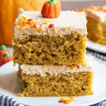 Pumpkin bars stacked on top of each other with a pumpkin candy on top with sprinkles.