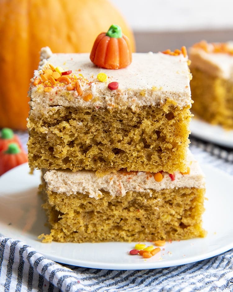 Pumpkin bars stacked on top of each other with a pumpkin candy on top with sprinkles.