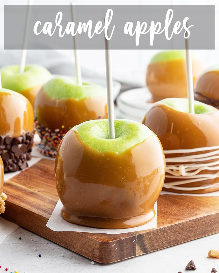 A caramel covered apple on a wooden board with text overlay for pinterest.