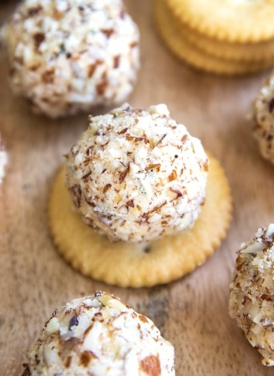 A mini cheese ball bite on a ritz cracker.