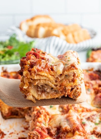 A piece of lasagna on a spatula being lifted out of the pan.
