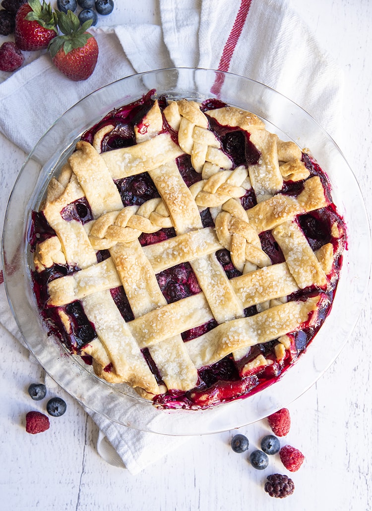A berry pie with a lattice top, with a couple braided pieces of pie crust on top too.