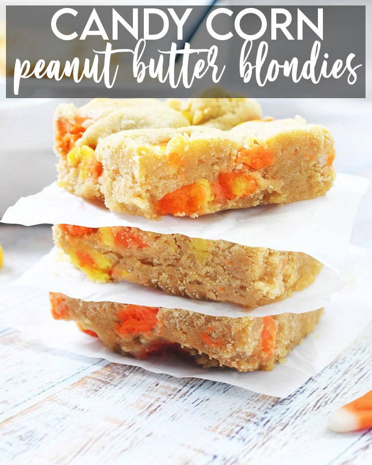 A stack of candy corn blondies with parchment paper between each one, with a text overlay for pinterest that says Candy Corn Peanut Butter Blondies.