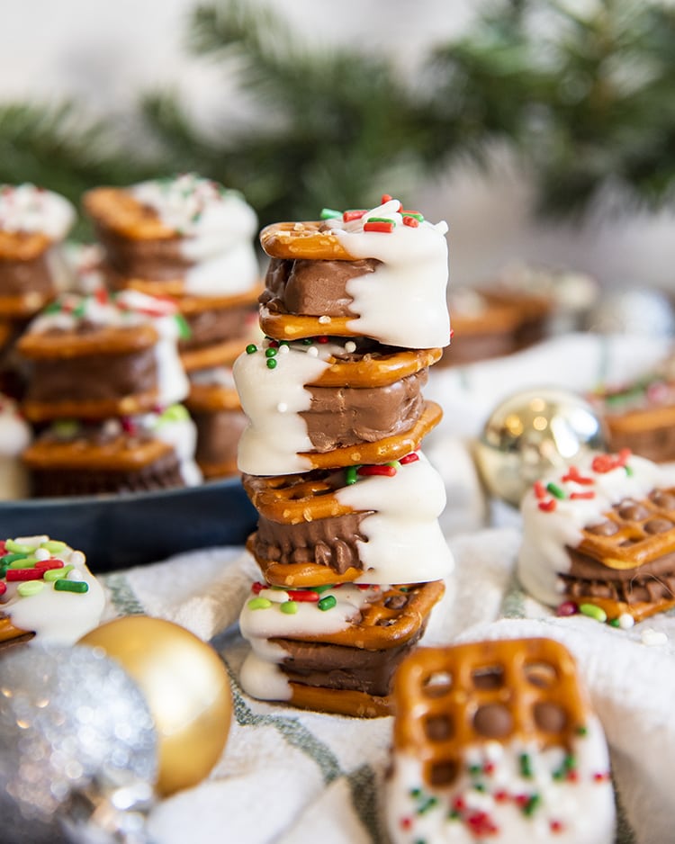 A stack of 4 candy bar pretzel bites, which are a mini candy bar sandwiched between pretzel snaps.