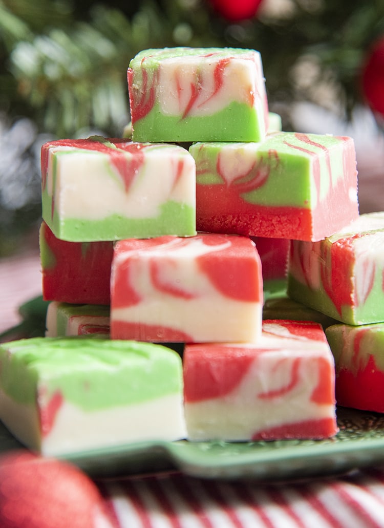 A pile of red, green, and white swirled fudge on a green plate.