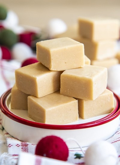 A small plate stacked with a light brown colored peanut butter fudge in a pile.