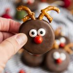 An Oreo dipped in chocolate and decorated with candy eyes and pretzels to look like a reindeer.