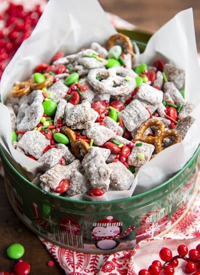 A tin full of Christmas muddy buddies, with red and green m&ms.