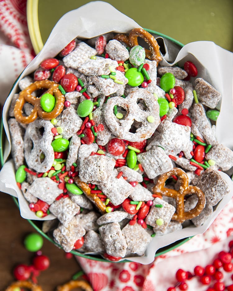 A christmas tin full of Reindeer chow which is muddy buddies with red and green m&ms, and mini pretzels.