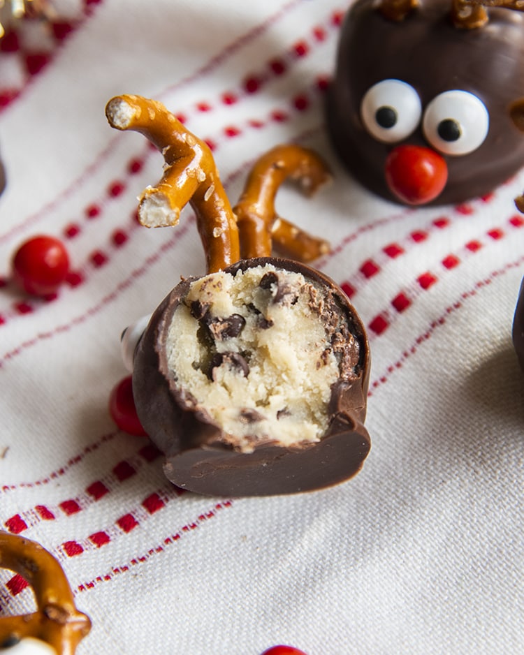 A cookie ball bit in half showing cookie dough with chocolate chips in the middle.