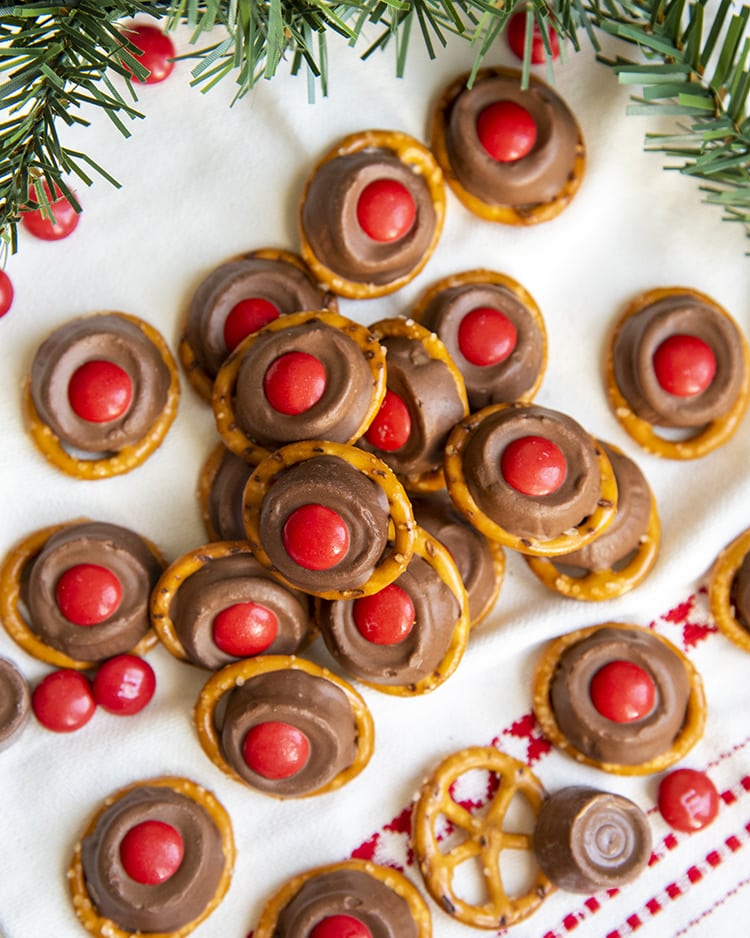 A pile of rolo pretzel treats on a white and red cloth.