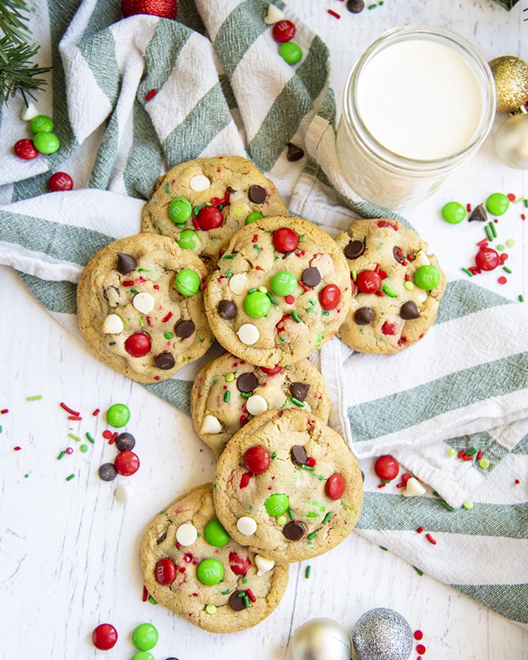 A pile of Christmas cookies on a green and white striped cloth.