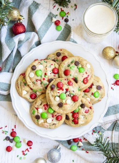A plate of Christmassy chocolate chip cookies with red and green m&ms, perfect for Santa.