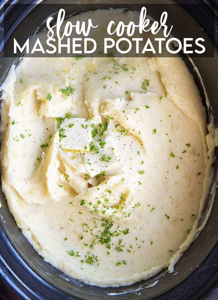 Mashed Potatoes in a slow cooker topped with butter and sprinkled parsley. There is a text overlay at the top for pinterest saying Slow Cooker Mashed Potatoes.
