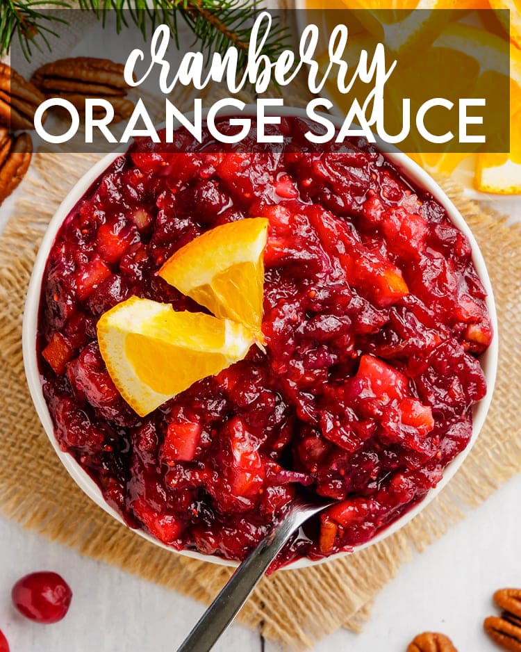 A bowl of cranberry sauce topped with a couple small orange slices with a spoon in the bowl with a text overlay for pinterest.