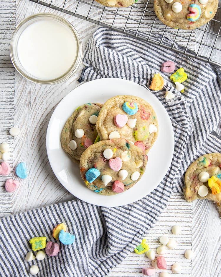 An overhead of three lucky charms cookies on a white plate.