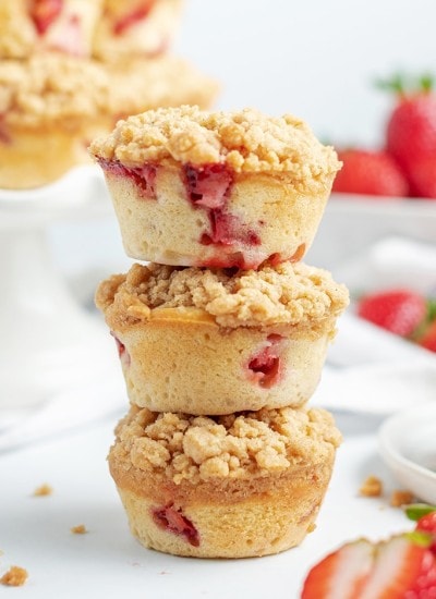 A stack of three strawberry muffins with crumble topping.