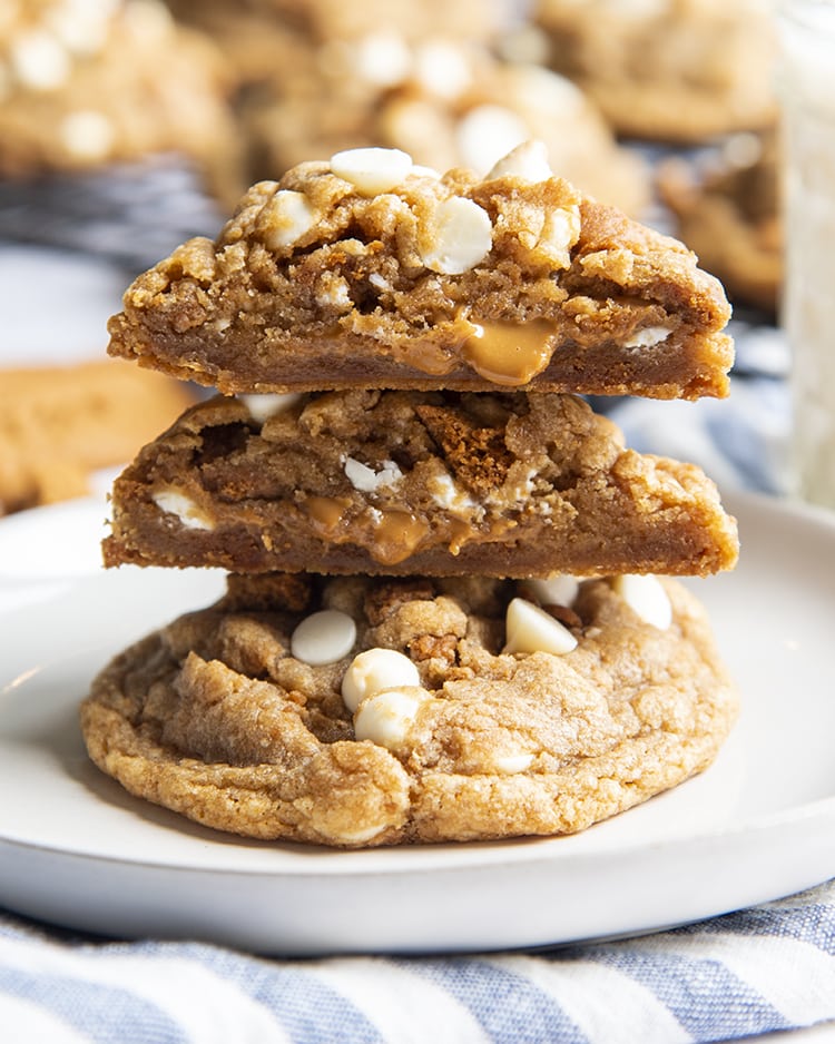 A stack of two giant cookies on a plate, one cookie is cut open showing cookie butter in the middle.