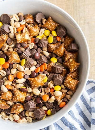An overhead photo of a white bowl full of Chocolate Peanut Butter snack mix.