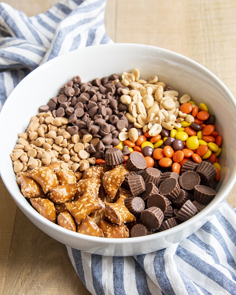 A bowl full of the ingredients for a chocolate peanut butter snack mix with segmented ingredients.