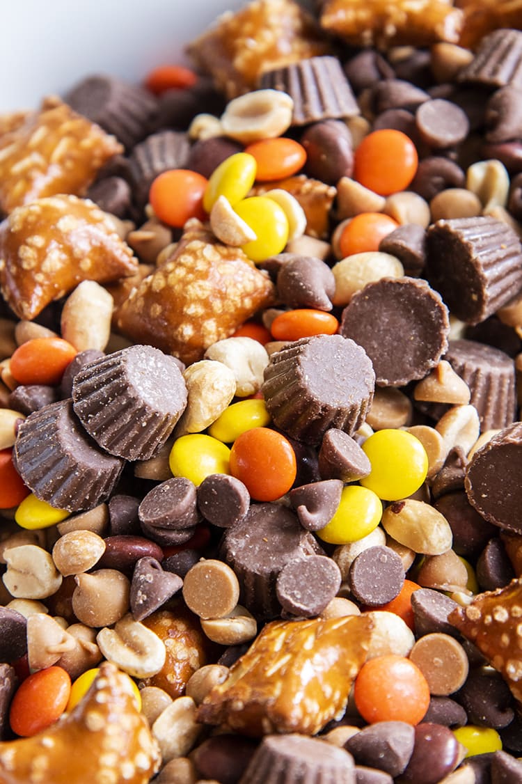 A close up of a chocolate peanut butter trail mix full of peanut related ingredients.