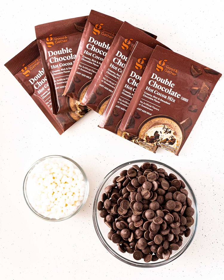 Showing the ingredients needed to make hot chocolate bombs, how cocoa packs, couverture chocolate, and mini marshmallows.