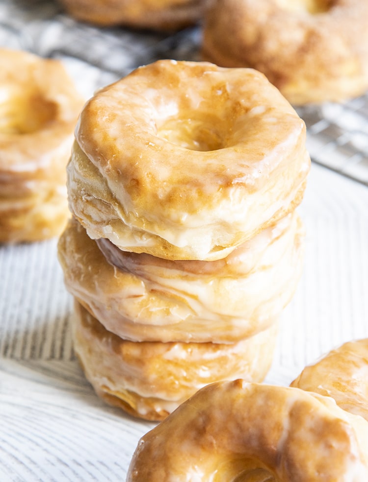 A stack of three air fryer donuts covered in a vanilla glaze.