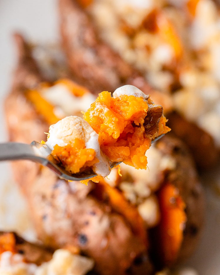 A bite of sweet potato and toasted marshmallow on a fork.