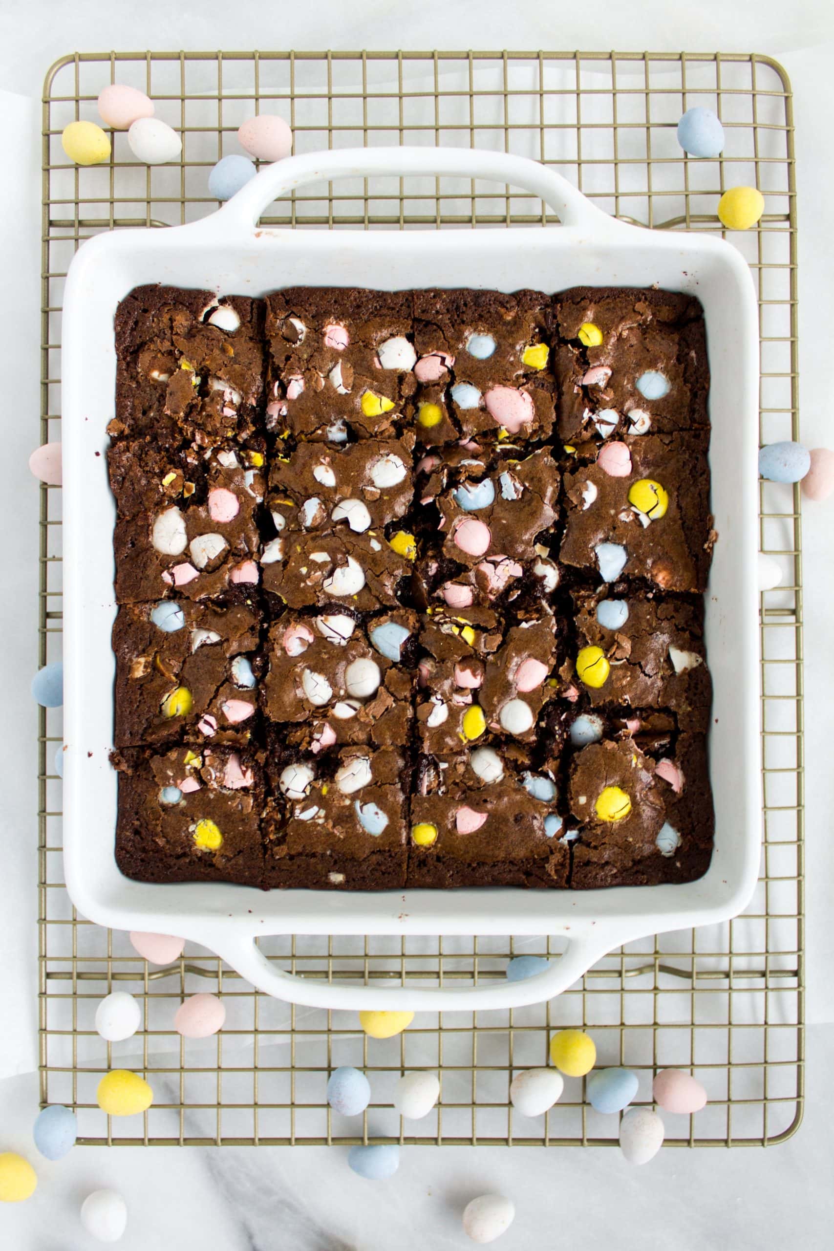 A square pan full of brownies that are full of chopped up cadbury mini eggs.
