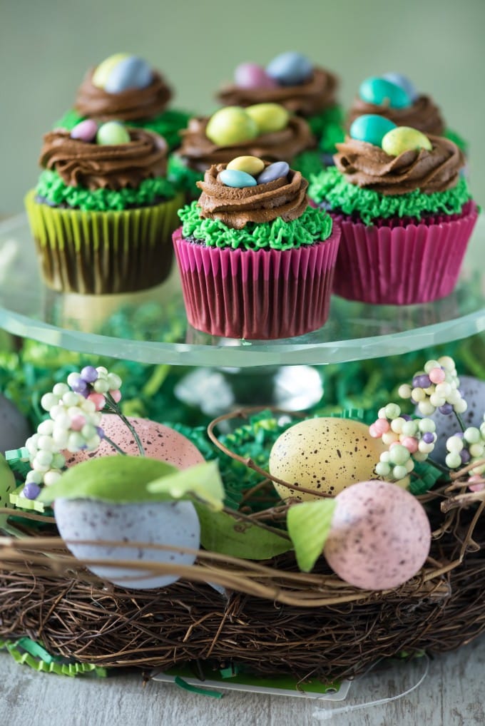 Cupcakes decorated with a green frosting to look like grass, and a brown frosting to look like a nest, and m&ms on top for eggs.