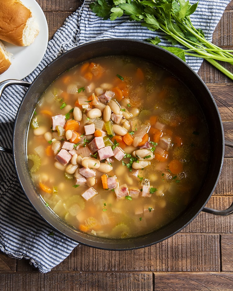An overhead photo of ham and bean soup in big pot.