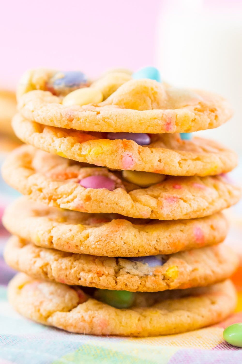 A stack of cookies full of pastel colored sprinkles and m&ms