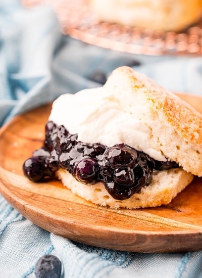A biscuit shortcake with blueberry sauce and whipped cream in the middle.