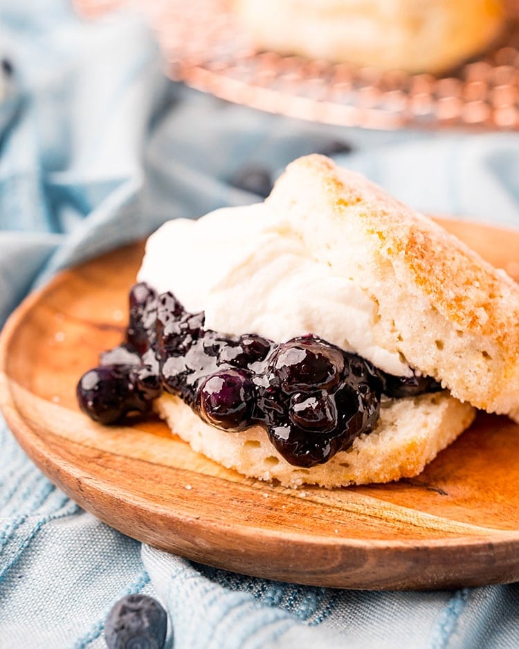 A biscuit shortcake with blueberry sauce and whipped cream in the middle.
