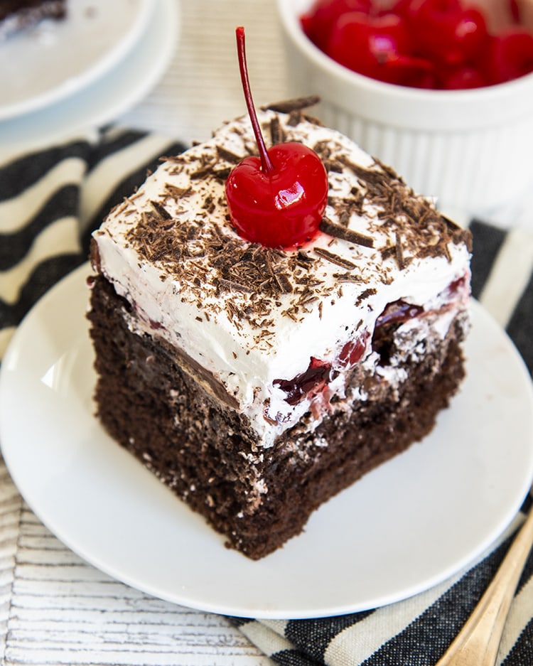 A piece of chocolate cake on a plate with Whipped Cream