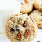 A brown butter banana cookie leaning on a glass.