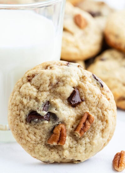 A brown butter banana cookie leaning on a glass.