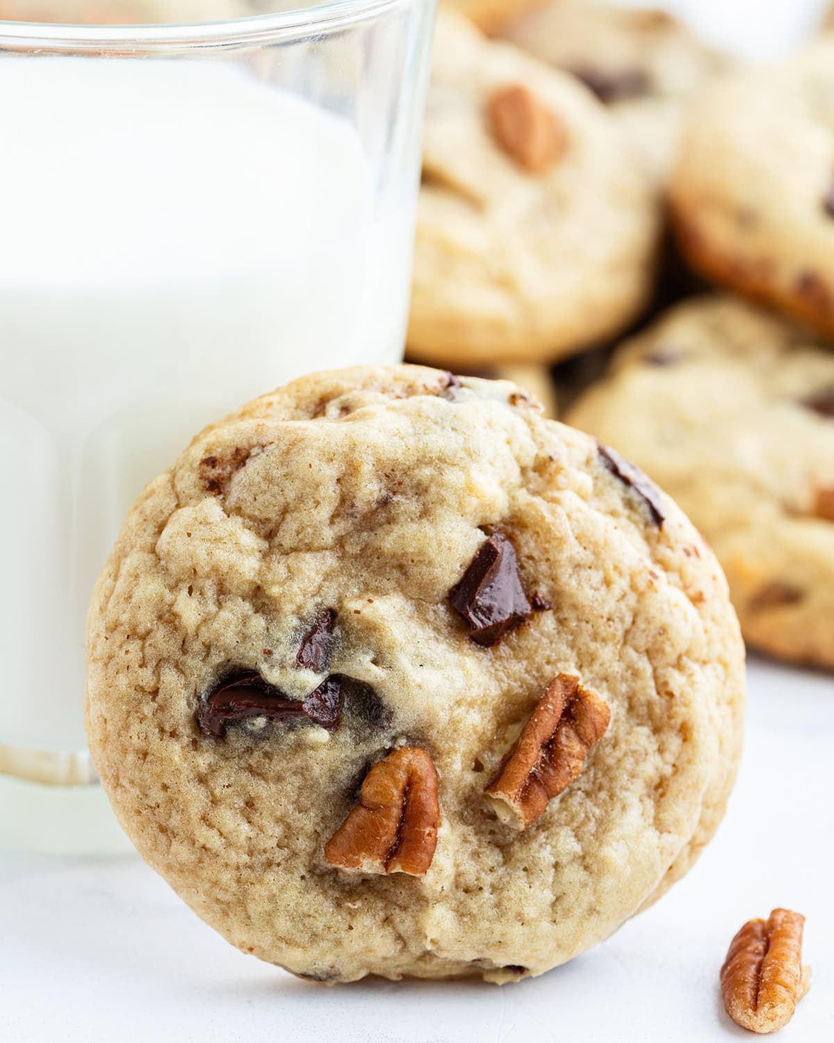 A brown butter banana cookie leaning on a glass.